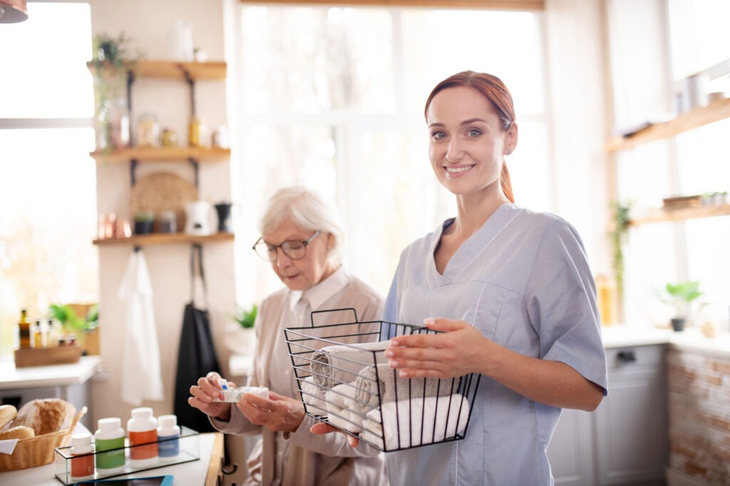 Cuidadora com produtos de higiene em casa de pessoa idosa, ambiente organizado e de confiança.
